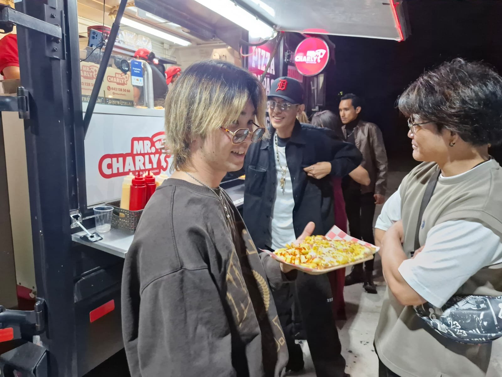 Personas disfrutando pizza en Mr. Charly Pizza